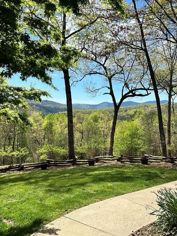 surrounding community with a mountain view and a lawn