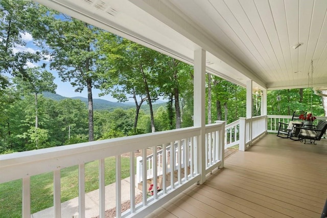 wooden terrace featuring a mountain view and covered porch