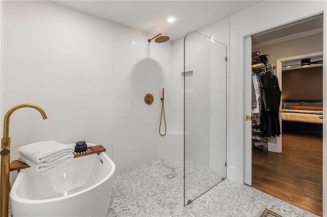 bathroom with wood finished floors, a walk in shower, a freestanding bath, and a sink