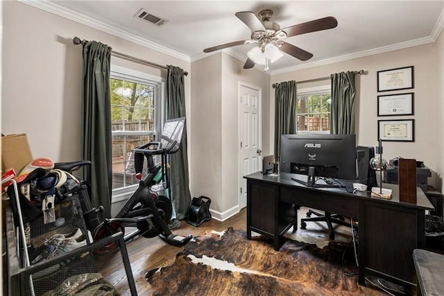 office space featuring visible vents, wood finished floors, baseboards, and ornamental molding