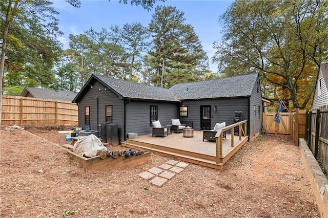 back of property with a wooden deck and a fenced backyard