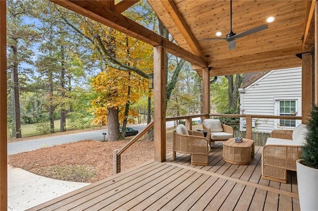 wooden deck featuring an outdoor living space and ceiling fan