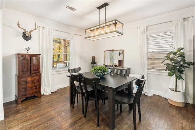 dining area with visible vents, baseboards, dark wood-type flooring, and ornamental molding