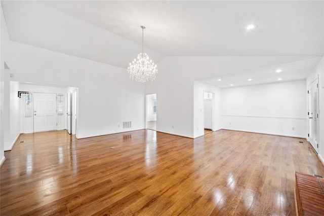 unfurnished living room with light wood-style floors, high vaulted ceiling, visible vents, recessed lighting, and a chandelier