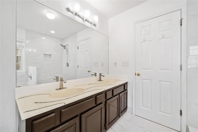 bathroom featuring a sink, a marble finish shower, marble finish floor, and double vanity
