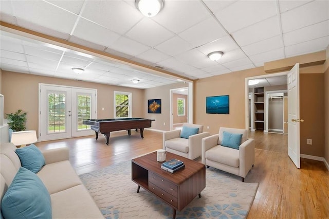 living room with pool table, light wood-type flooring, french doors, and a drop ceiling