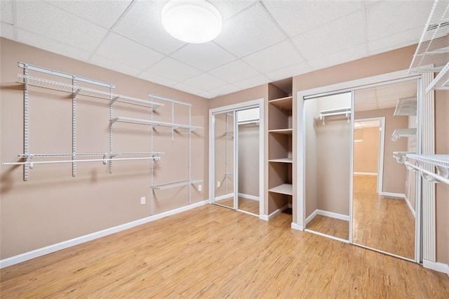 walk in closet featuring a paneled ceiling and wood finished floors