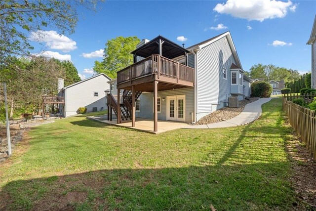 back of property with a lawn, fence, a patio, french doors, and a wooden deck