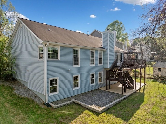 rear view of house with a patio, a chimney, stairway, a deck, and a lawn