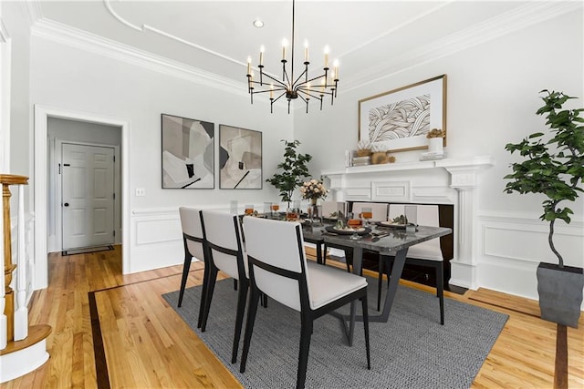 4011 Charrwood Trce, Marietta, GA 30062 - dining area featuring a chandelier, ornamental molding, light wood-style flooring, a wainscoted wall, and a decorative wall