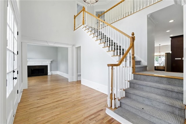 4011 Charrwood Trce, Marietta, GA 30062 - stairs with a chandelier, a high ceiling, wood finished floors, a fireplace, and crown molding
