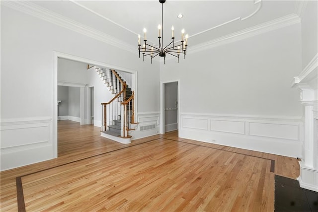4011 Charrwood Trce, Marietta, GA 30062 - unfurnished dining area featuring stairway, crown molding, a chandelier, wood finished floors, and a wainscoted wall