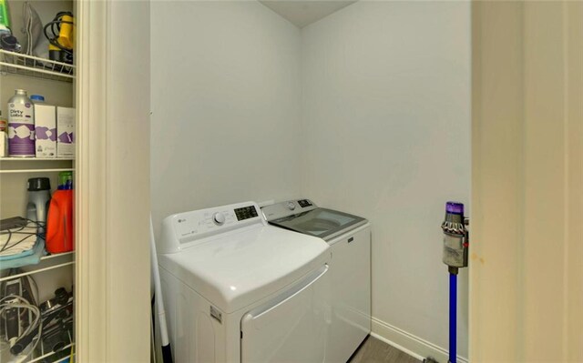 laundry room featuring washer and dryer and hardwood / wood-style flooring