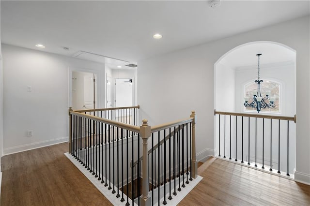 hall featuring wood finished floors, recessed lighting, an upstairs landing, and baseboards