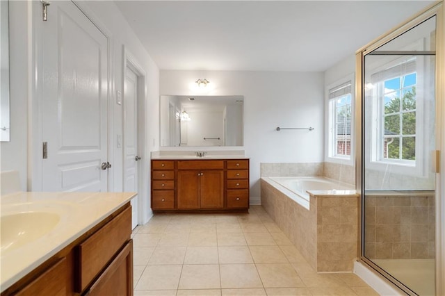 full bathroom featuring a garden tub, two vanities, a stall shower, a sink, and tile patterned floors