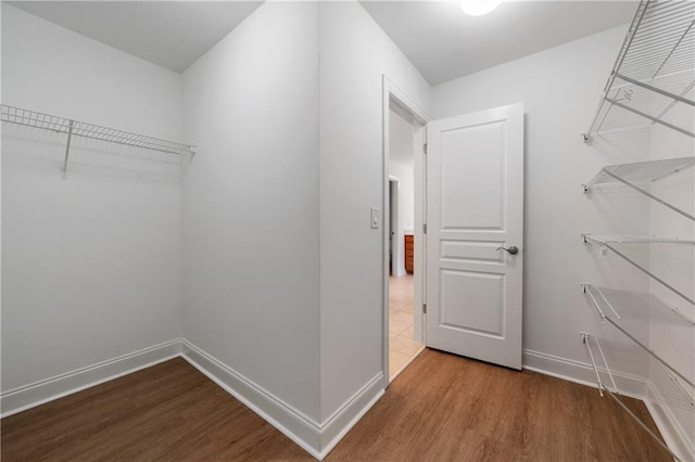 walk in closet with wood finished floors