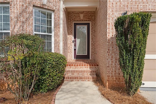 entrance to property featuring brick siding