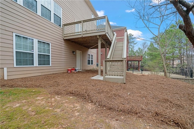 back of house with stairs, a deck, and fence