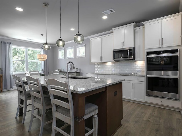 712 Broken Arrow, Waleska, GA 30183 - kitchen featuring stainless steel appliances, a kitchen island with sink, light stone counters, decorative backsplash, and white cabinetry