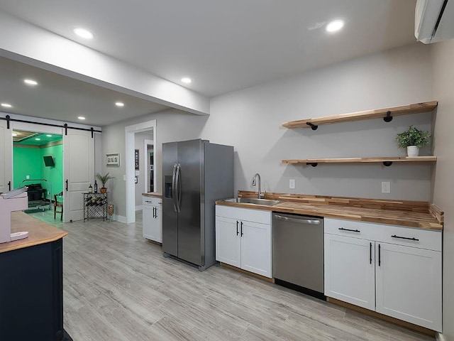 712 Broken Arrow, Waleska, GA 30183 - kitchen with appliances with stainless steel finishes, a barn door, wooden counters, an AC wall unit, and light wood finished floors