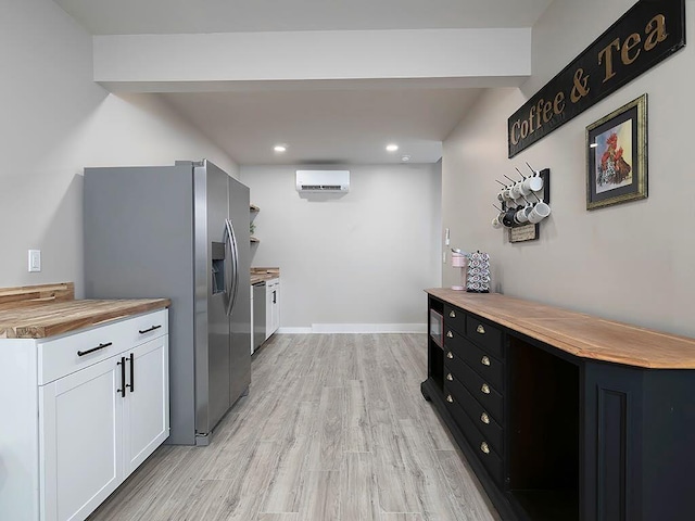 712 Broken Arrow, Waleska, GA 30183 - kitchen featuring a wall mounted air conditioner, wooden counters, appliances with stainless steel finishes, white cabinets, and light wood-type flooring