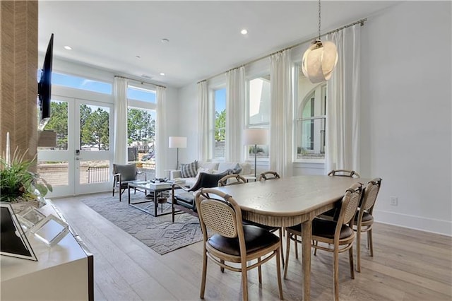 dining room featuring light wood-type flooring, baseboards, a wealth of natural light, and recessed lighting