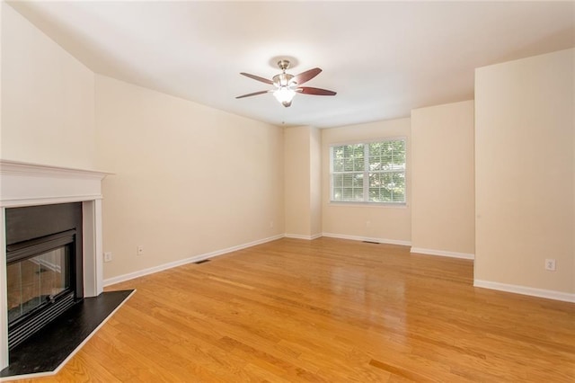 2104 Meadow Peak Rd, Duluth, GA 30097 - unfurnished living room featuring a glass covered fireplace, light wood finished floors, a ceiling fan, and baseboards