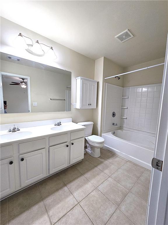 2104 Meadow Peak Rd, Duluth, GA 30097 - bathroom with double vanity, bathtub / shower combination, toilet, tile patterned floors, and a ceiling fan