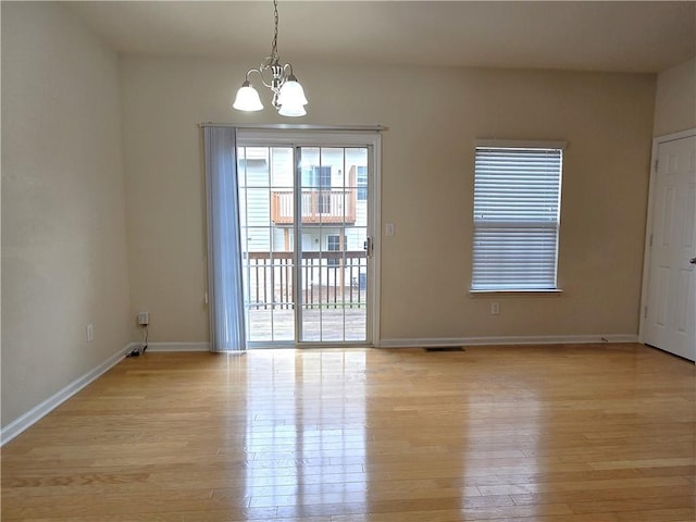 2104 Meadow Peak Rd, Duluth, GA 30097 - empty room with a chandelier, light wood finished floors, and baseboards