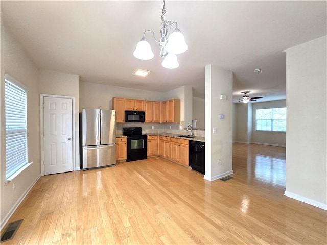 2104 Meadow Peak Rd, Duluth, GA 30097 - kitchen with black appliances, a sink, a chandelier, light wood-style floors, and light brown cabinetry