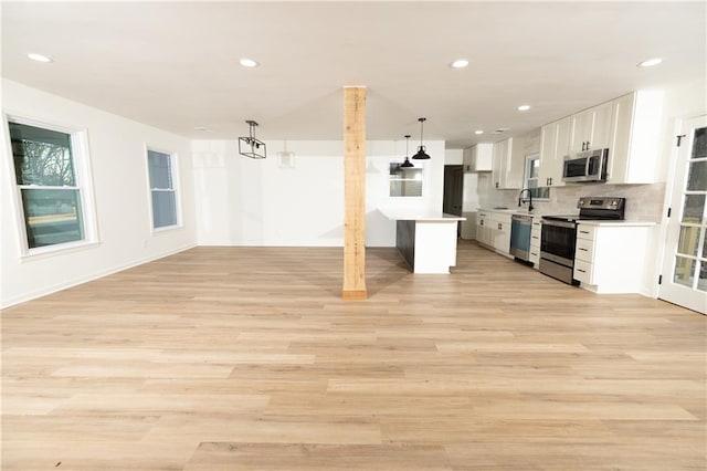 4336 Parkview Dr, Lithia Springs, GA 30122 - kitchen with light countertops, light wood finished floors, white cabinetry, open floor plan, and stainless steel appliances