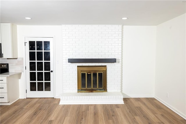 4336 Parkview Dr, Lithia Springs, GA 30122 - unfurnished living room featuring a brick fireplace, recessed lighting, baseboards, and wood finished floors