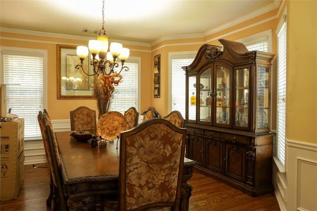 dining space with ornamental molding, an inviting chandelier, plenty of natural light, and dark wood-type flooring