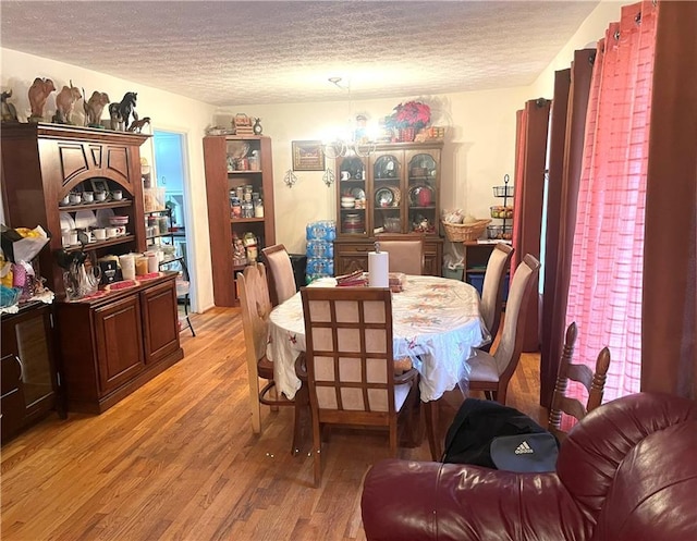 dining room with a textured ceiling and light wood-type flooring