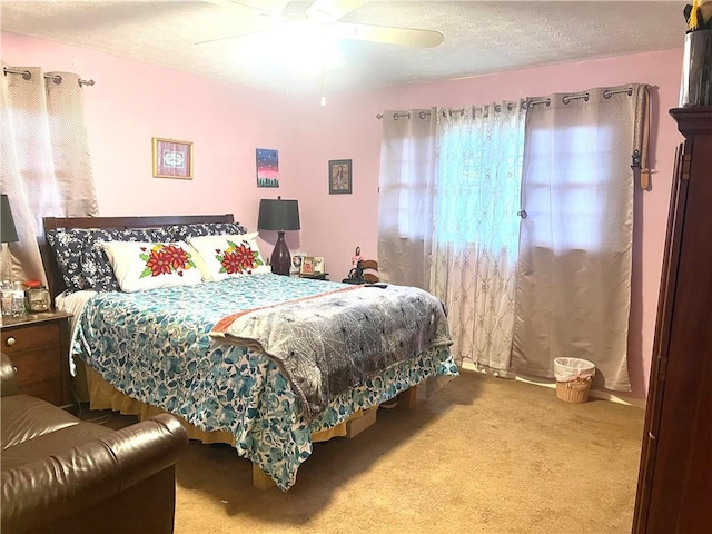 bedroom featuring ceiling fan, a textured ceiling, and carpet