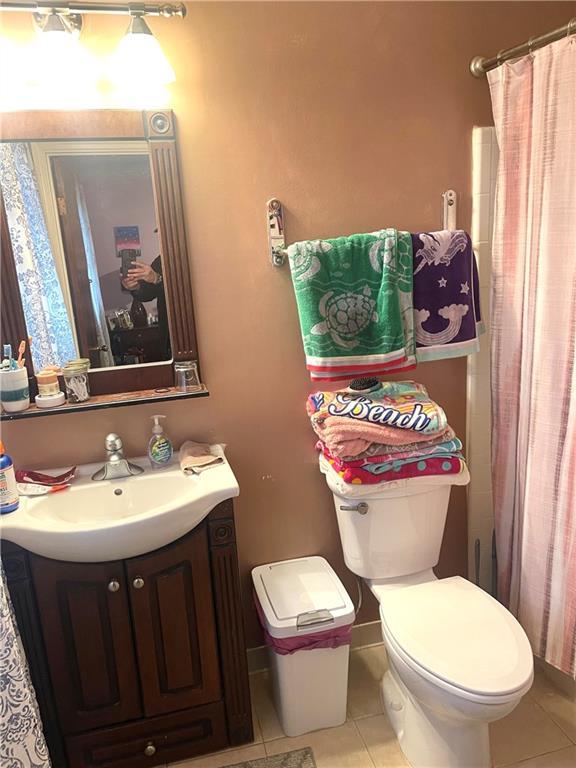 bathroom featuring tile patterned flooring, vanity, and toilet