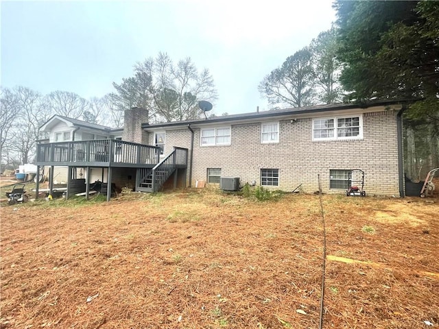 back of house with central AC unit, a yard, and a deck