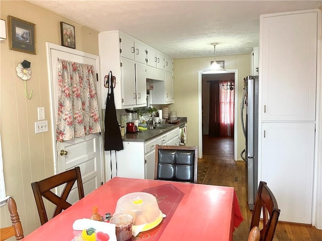 kitchen with white cabinetry, sink, dark wood-type flooring, and stainless steel refrigerator