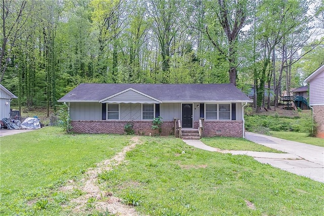 ranch-style house with covered porch, board and batten siding, brick siding, and a front yard
