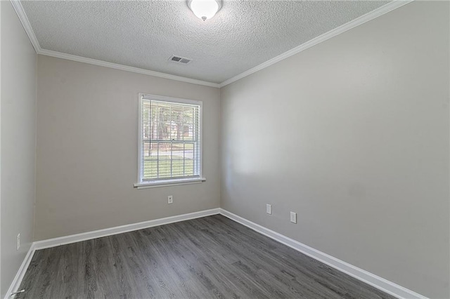 spare room featuring ornamental molding, a textured ceiling, dark wood-type flooring, and visible vents