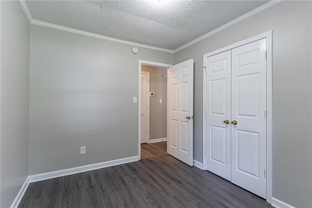 unfurnished bedroom with dark wood-style flooring, a textured ceiling, a closet, and baseboards