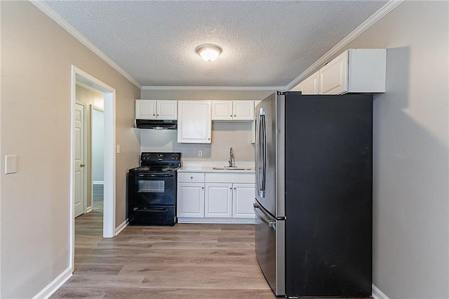 kitchen featuring a sink, freestanding refrigerator, black / electric stove, white cabinetry, and exhaust hood