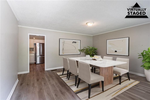 dining space with ornamental molding, a textured ceiling, dark wood-type flooring, visible vents, and baseboards