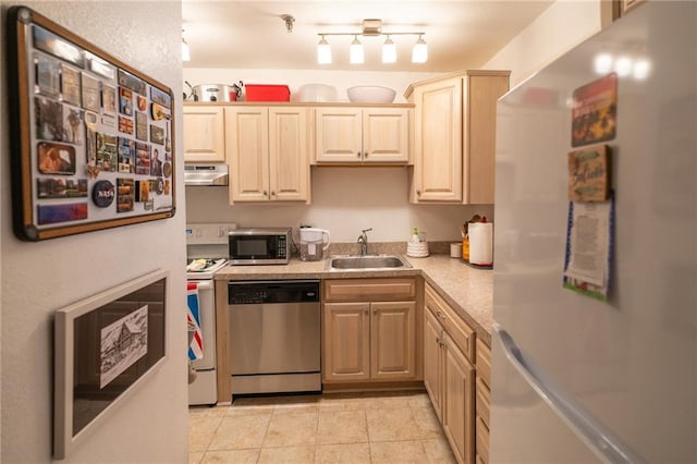 kitchen with stainless steel appliances, sink, light tile patterned floors, and light brown cabinetry