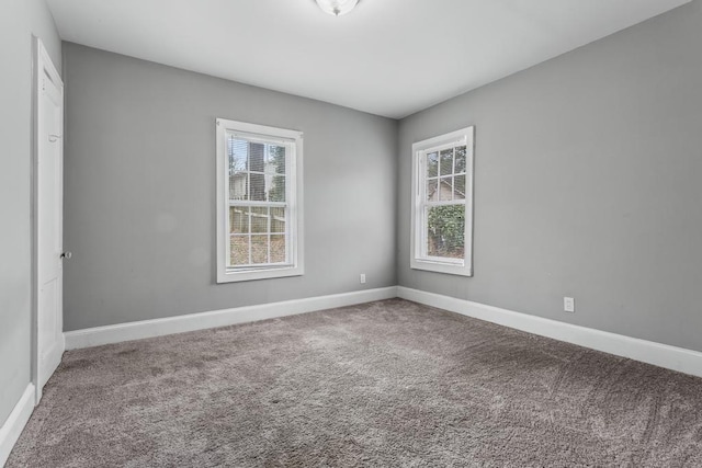 unfurnished room with carpet flooring and baseboards