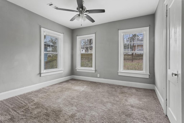 carpeted spare room with baseboards and a ceiling fan