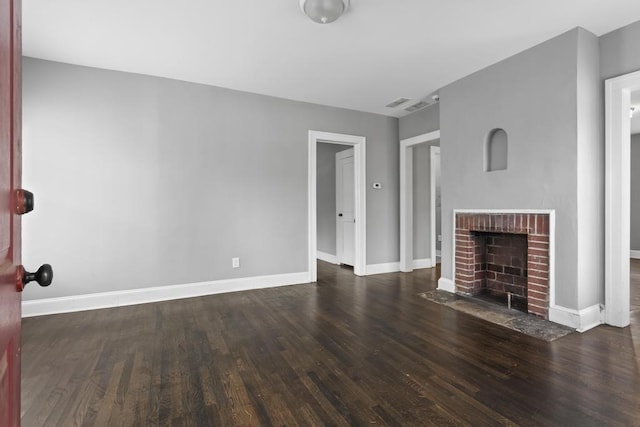 unfurnished living room featuring a fireplace, baseboards, and wood finished floors