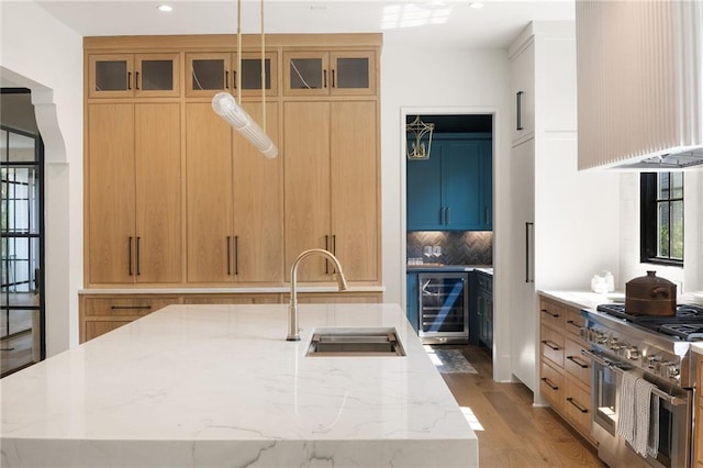 555 Orme Cir NE, Atlanta, GA 30306 - kitchen with a sink, extractor fan, wine cooler, stainless steel range, and backsplash