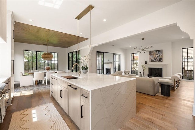555 Orme Cir NE, Atlanta, GA 30306 - kitchen featuring a sink, light wood-style flooring, healthy amount of natural light, recessed lighting, and hanging light fixtures