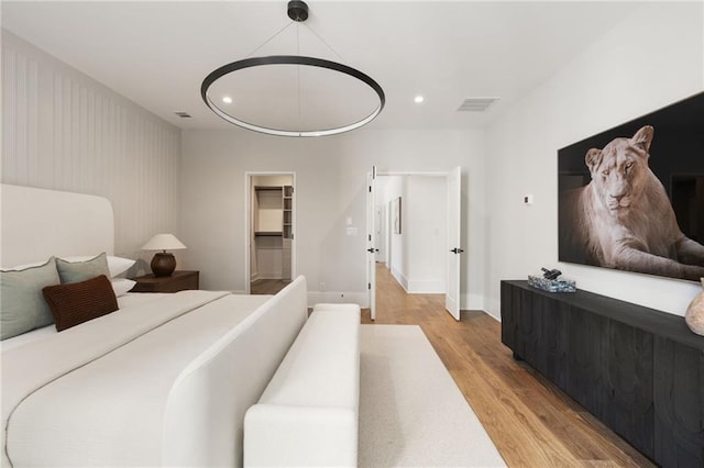 555 Orme Cir NE, Atlanta, GA 30306 - bedroom with light wood-style floors, recessed lighting, baseboards, and a walk in closet